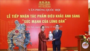 Le président de l'Assemblée nationale, Tran Thanh Man, remet un cadeau à l'artisan Bui Van Tu. Photo : VNA.