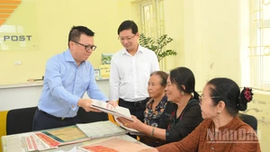 Le rédacteur en chef Le Quoc Minh a offert aux habitants locaux le supplément spécial publiant les projets de documents soumis au XIVe Congrès national du Parti.