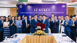 Đao Xuan Co, directeur de l'Hôpital Bach Mai et Nguyên Van Khoa, directeur général du Groupe FPT, échangeant l'accord de coopération.