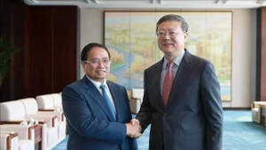 Le Premier ministre Pham Minh Chinh (gauche) et Chen Jining, membre du Bureau politique du Comité central du Parti communiste chinois (PCC) et secrétaire du Comité du PCC pour la ville de Shanghai. Photo: VNA