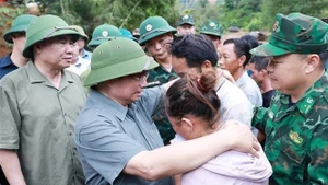 Le Premier ministre Pham Minh Chinh et des sinistrés. Photo : VNA.