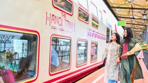 Des visiteurs font l'expérience du train des cinq portes d'Hanoi, un nouveau produit touristique. (Photo : BAO LONG)