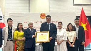 Le président du Comité central du Front de la Patrie du Vietnam, Do Van Chien, a remis un certificat de mérite au collectif de l’Association des Entrepreneurs et Investisseurs Vietnam-République de Corée. Photo : VKBIA. 