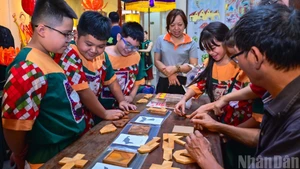 Les élèves de l’école primaire Tran Nhat Duat participent avec enthousiasme au jeu Tri Uan dans l’espace culturel et artistique de Hang Buom, à Hanoi, capitale vietnamienne.