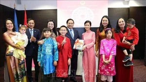 Le Premier ministre vietnamien Pham Minh Chinh et son épouse offrent des livres d'apprentissage du vietnamien à la communauté des Vietnamiens en Estonie. Photo : VNA.