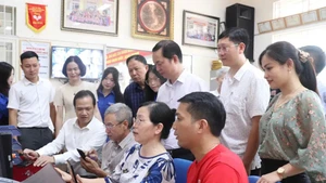 De nombreuses personnes âgées, autrefois peu à l’aise avec les smartphones, savent désormais ouvrir des applications, déposer des dossiers en ligne et rechercher les informations nécessaires. Photo : KTĐT.