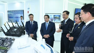 Le Premier ministre Pham Minh Chinh (2e, de gauche à droite) visite la salle des traditions et des produits technologiques de VNPT. Photo : NDEL.