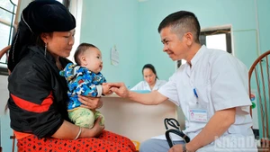 Le docteur Nguyen Duy Dong examine un petit patient au poste médical de Lung Cu.