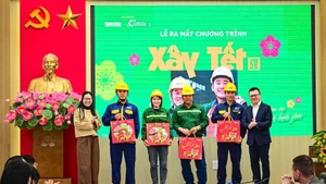 Les représentants de la direction du Nhân Dân et de la société Coteccons offrent des cadeaux aux ouvriers de Coteccons et de la SARL d’assainissement de Hanoï.