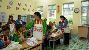 Des artisans initient les apprenants de la classe de confection de costumes traditionnels de l’ethnie Mang. Photo : baodantoc.