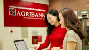 Des employés de la Banque vietnamienne de l’Agriculture et du Développement rural (Agribank) guident les clients dans la réalisation de transactions sécurisées sur les canaux numériques. Photo : Journal Quân đội nhân dân.