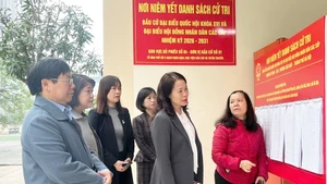Les dirigeants du quartier de Cau Giay ont inspecté le travail d’affichage officiel ainsi que la préparation des infrastructures matérielles au sein du bureau de vote n°4. Photo : HNM