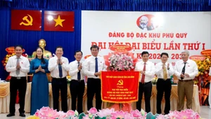 Le camarade Y Thanh Ha Niê Kđăm, membre du Comité central du Parti, secrétaire du Comité provincial du Parti de Lam Dong, remet un drapeau au Comité du Parti de la zone spéciale de Phu Quy. Photo : NDEL.