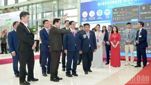 Le Premier ministre Pham Minh Chinh et des responsables gouvernementaux visitent le stand du Réseau de services multichaîne Blockchain Vietnam. Photo : HD.