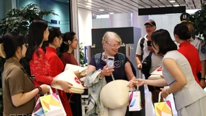 Offre des cadeaux aux passagers venus de Manille (Philippines) et de Bali (Indonésie). Photo : VNA.