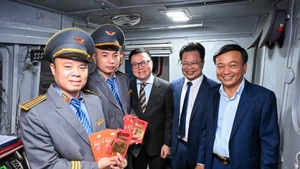 Le rédacteur en chef du Journal Nhân Dân, Le Quoc Minh, et le vice-ministre de la Construction Nguyen Danh Huy, aux côtés des dirigeants de la Compagnie nationale des chemins de fer du Vietnam, offrent des présents aux cadres du secteur ferroviaire. 