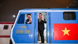 Le Quoc Minh, le rédacteur en chef du Journal Nhân Dân, et Dang Sy Manh, président du Conseil des membres de la Compagnie nationale des chemins de fer du Vietnam, à bord du « Train du Bonheur » dans la nuit du réveillon.