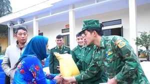 Sourire aux lèvres, les soldats remettent avec attention les cadeaux du Têt aux habitants. Photo : QĐND. 