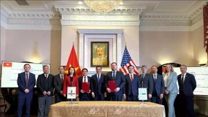 La cérémonie de signature d'un protocole d'accord entre des représentants vietnamiens et américains. Photo : VNA.