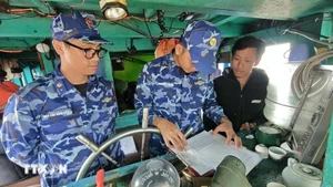 Des garde-côtes vietnamiens de la Zone 2 sensibilisent les pêcheurs au respect des réglementations relatives à la lutte contre la pêche illicite, non déclarée et non réglementée. Photo : VNA.