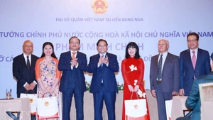 Le Premier ministre Pham Minh Chinh (au centre) remet des cadeaux à la communauté vietnamienne en Russie. Photo : VNA.