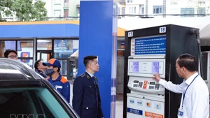 La force de gestion du marché de Hanoï surveille les activités commerciales d’une station-service de Petrolimex sur la rue Tran Quang Khai, à Hanoï. Photo : VNA.