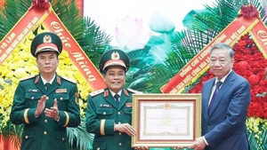 Le secrétaire général du PCV, To Lam (à droite), remet le titre de Héros des Forces armées populaires au Département général de la Logistique et de la Technique relevant du ministère de la Défense. Photo : VNA.