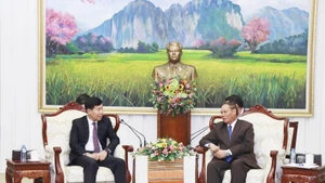 Vilay Lakhamphong (à droite), membre du Bureau Politique et permanent du Secrétariat du Parti populaire révolutionnaire lao (PPRL) reçoit Nguyen Manh Cuong, vice-ministre vietnamien des Affaires étrangères. Photo : VNA.