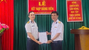 Le camarade Nguyen Thanh Hai (à gauche) reçoit sa décision officielle d’admission au PCV. Photo : QĐND.