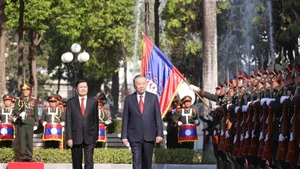 Le secrétaire général du PCV, To Lam et le secrétaire général du PRPL et président lao Thongloun Sisoulith passent en revue la garde d’honneur de l’Armée populaire lao (APL). Photo : VNA.