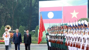 Les dirigeants To Lam et Thongloun Sisoulith passent en revue la garde d'honneur de l'Armée populaire vietnamienne. Photo : VNA.