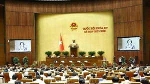 Les députés écoutent le rapport demandant à l’Assemblée nationale d’approuver la résolution sur la réorganisation des unités administratives provinciales et le rapport de vérification. Photo : VNA
