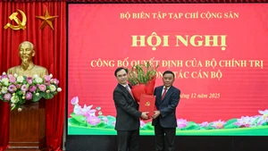 Le membre du Bureau politique et permanent du Secrétariat du Parti communiste du Vietnam (PCV), Tran Cam Tu, remet la décision du Bureau politique et offre des fleurs de félicitations au camarade Duong Trung Y. (Photo : DUY LINH)