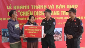 Le général de division Pham Hong Phuc (à droite), du commandement de la police mobile, félicite la famille de Nguyen Dinh, commune de Thuong Duc, pour leur nouvelle maison. Photo : VNA.