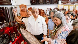 Des visiteurs internationaux découvrent avec enthousiasme et participent à des expériences au village artisanal de marqueterie de nacre de Chuyen My. Photo : Minh Loc