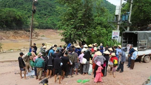 Des habitants encore isolés reçoivent des vivres, denrées alimentaires et produits de première nécessité d’actions caritatives au village de Xieng Tam (commune de My Ly, province de Nghe An) avant d’être acheminés en barque vers les hameaux. Photo : VNA.