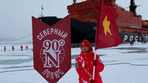 Un jeune explorateur hisse le drapeau rouge à étoile d’or au pôle Nord