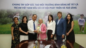 La représentante d’Operation Smile, Mme Kathleen Soracco Magee, a pris une photo souvenir avec la direction du Fonds de protection des enfants du Vietnam. Photo : NFVC.