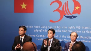 Le président vietnamien Luong Cuong (au centre) à la rencontre des vétérans vietnamiens et américains. Photo : VNA.