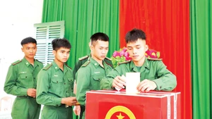 Un soldat du poste-frontière de Dak M'Bai, commune de Thuan An, lors du vote au groupe électoral n°21.
