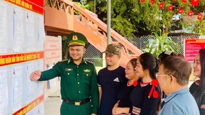Le capitaine Y Han H’Wing, chef de l’équipe de mobilisation des masses du poste-frontière de Srepok, guide les habitants dans l’exercice de leurs droits et devoirs civiques. Photo : Thanh Nga.