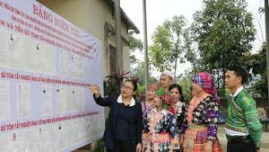 La cheffe du bureau de vote n°5 de la commune de Quy Mong, dans la province de Lao Cai, présente les candidats afin d’aider les habitants à mieux les connaître. Photo : VNA.