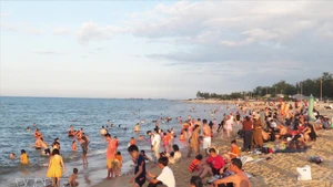 De nombreux habitants et touristes se rendent sur la plage de Thuan An à Hue pour se détendre et se baigner. Photo : VNA.