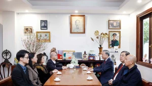 Le secrétaire général Tô Lâm converse avec des membres de la famille du Premier ministre Pham Van Dông. Photo : VNA.