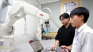 Des étudiants testent des algorithmes de commande d’un bras robotique au laboratoire de robotique de l’Université d’Industrie de Hô Chi Minh-Ville. Photo : VNA.
