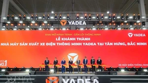 Les délégués procèdent à la cérémonie de coupe du ruban marquant l’inauguration de l’usine de production de motos électriques intelligentes YADEA dans la zone industrielle de Tân Hưng, province de Bac Ninh. Photo / VNA.