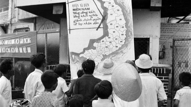 Les habitants du chef-lieu Phan Thiêt (Binh Thuân), récemment libéré, suivaient les nouvelles de la victoire sur la carte de la situation militaire dans la salle d'information du chef-lieu (en avril 1975). Photo : VNA.