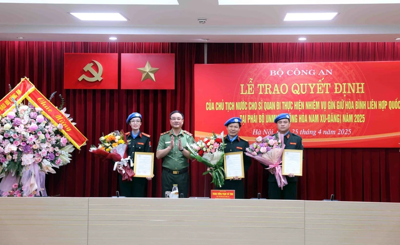 Le vice-ministre de la Sécurité publique Pham The Tung décerne la décision présidentielle à trois officiers qui participeront à la mission de maintien de la paix des Nations Unies au Soudan du Sud (MINUSS) en 2025. Photo : VNA.