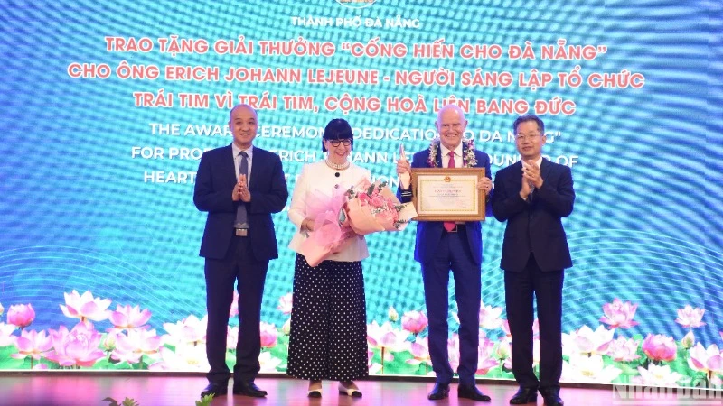 Les dirigeants municipaux décernent le prix “Dévouement à Da Nang” au couple Erich Johann Lejeune et Irène Lejeune, fondateurs de l’organisation "Heart for Heart". Photo : Nhân Dân.