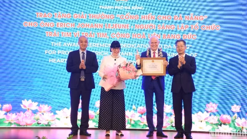 Les dirigeants municipaux décernent le prix “Dévouement à Da Nang” au couple Erich Johann Lejeune et Irène Lejeune, fondateurs de l’organisation "Heart for Heart". Photo : Nhân Dân.